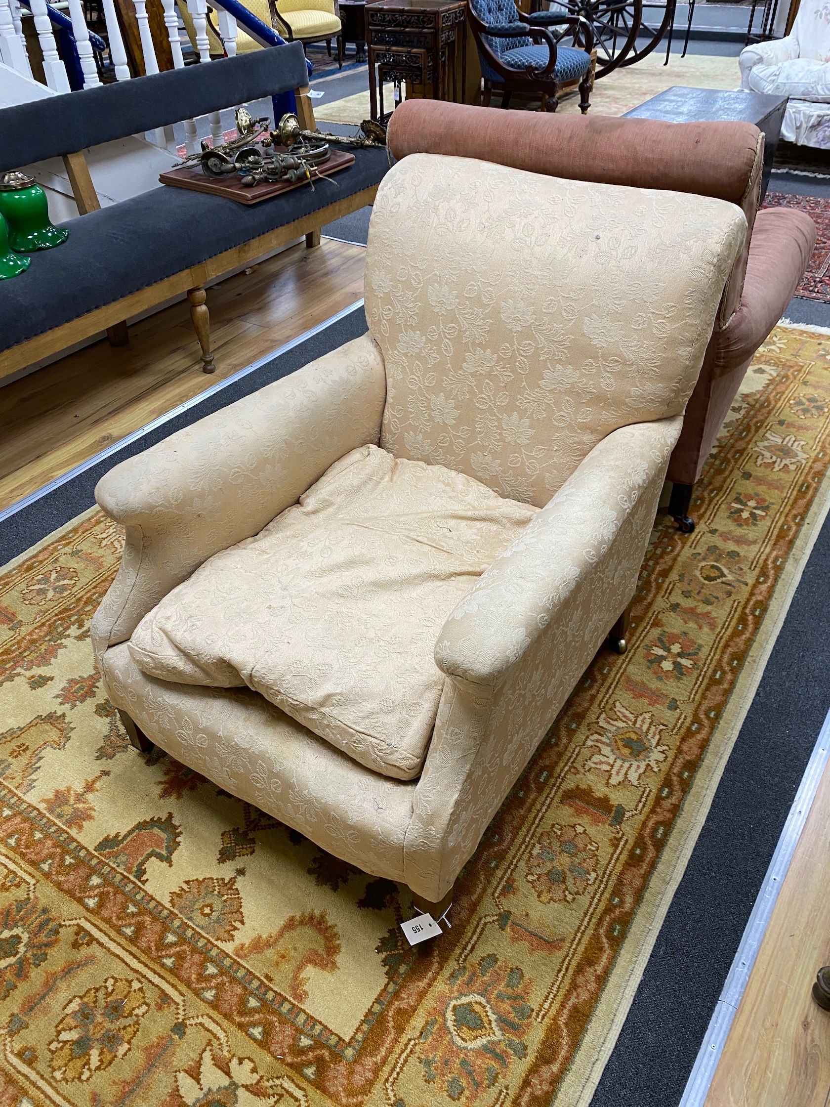 An Edwardian mahogany club armchair with squared tapered legs and brass castors, width 76cm, depth 100cm, height 88cm